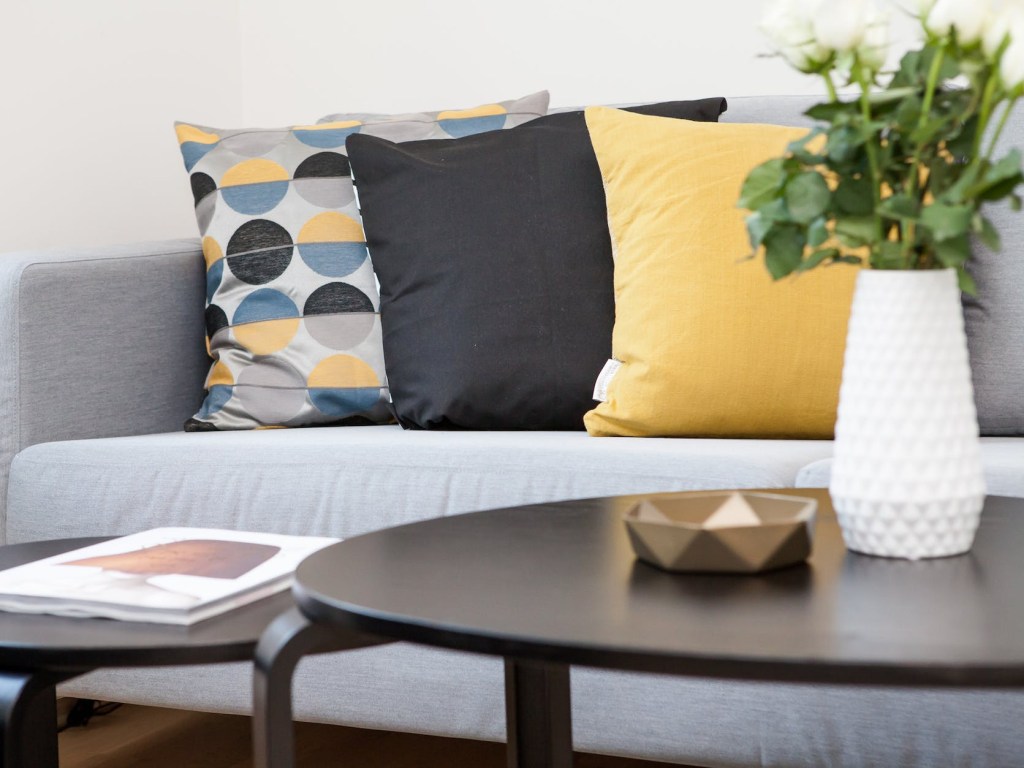 centerpiece on coffee table beside sofa with three pillows